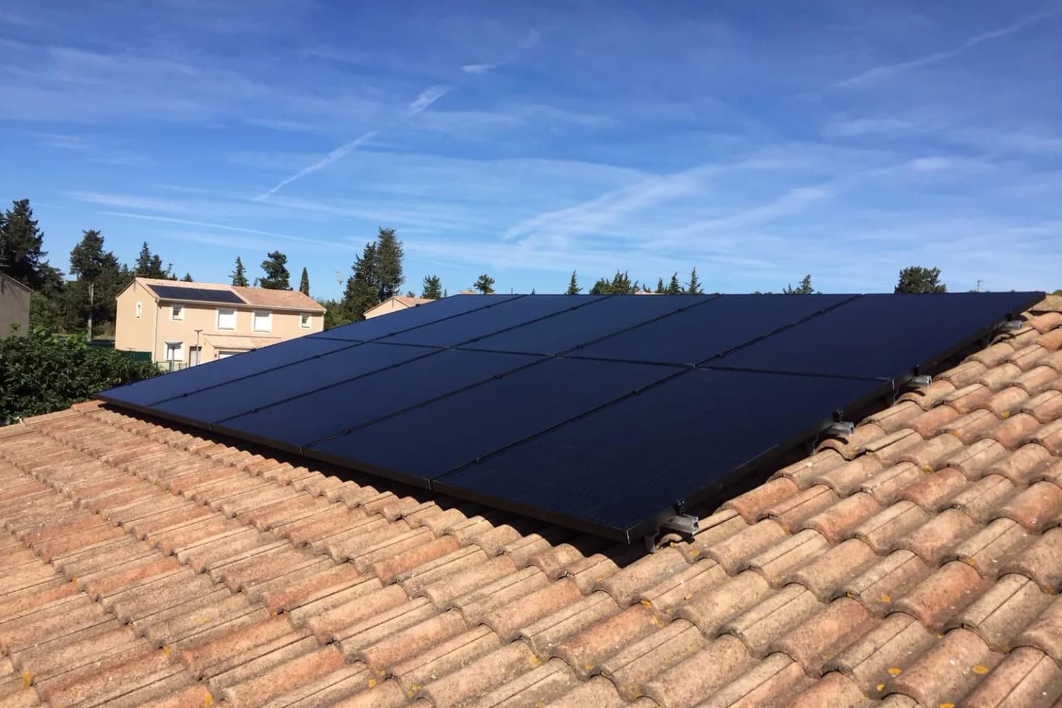 Panneaux solaires sur une toiture en tuiles sous un ciel bleu